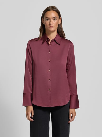 Frauenmodel trägt bordeauxrote Slim Fit Bluse aus Satin Modell 'IDEALE' von MANGO mit Hemdblusenkragen und Knopfleiste, Ganzkörperansicht von vorne. Rückenlänge 65 cm, Ärmellänge 61 cm.