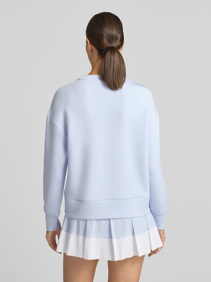 Frauenmodel trägt Sweatshirt aus Viskose-Mix Modell 'rasco' von VARLEY in Hellblau mit elastischen Abschlüssen, Ganzkörperansicht Rückansicht.