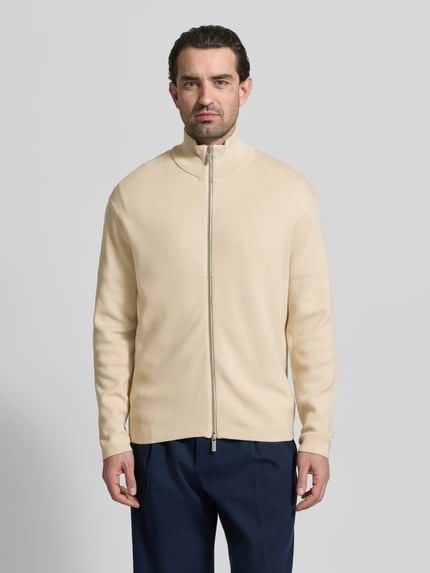 Männermodel trägt Relaxed Fit Strickjacke aus Viskose-Mix Modell 'TELLER' von SELECTED HOMME in Creme, Feinstrick, Ganzkörperansicht von vorne.