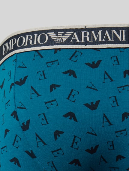 Produktfoto, Slim Fit Trunks aus Baumwoll-Mix von Emporio Armani in Blau mit elastischem Bund und Logo-Detail, Muster aus schwarzen Buchstaben und Symbolen
