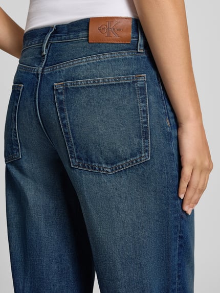 Vrouwenmodel draagt Baggy Jeans aus reiner Baumwolle van Calvin Klein Jeans in indigo katoendenim met rechte steekzakken, detailopname achteraan.
