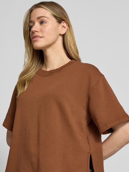 Vrouwenmodel draagt sweatshirt met 1/2-mouwen en ronde hals van Rich & Royal, mix van biologisch katoen met stretch, loose fit, zij-splitten, nahaufnahme bovenlichaam.