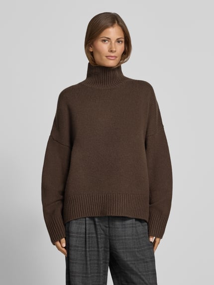 Frauenmodel trägt Wollpullover mit Rollkragen von Style Icon Collection, reine Wolle, lockerer Schnitt, gerippte Abschlüsse, Ganzkörperansicht von vorne.