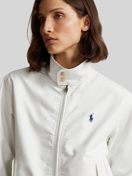Modelka prezentuje Regular Fit Blouson aus reiner Baumwolle von Polo Ralph Lauren, biały kolor, logo z przodu, krój regular fit, zbliżenie na górną część ciała.