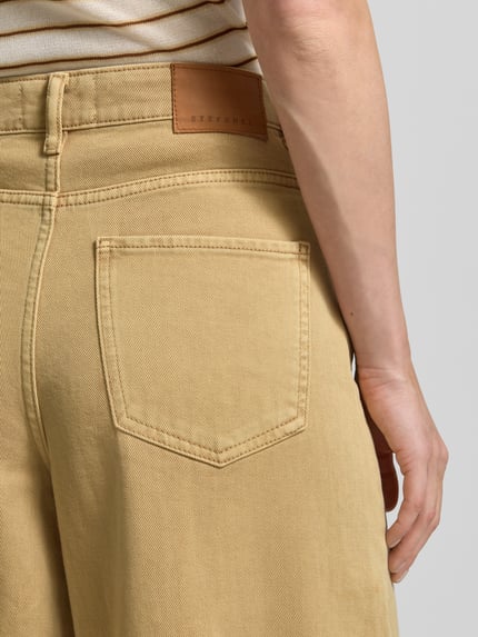 Frauenmodel trägt Wide Leg Jeans im 5-Pocket-Design von Stefanel in Beige, reine Baumwolle, ausgestellter Schnitt, Detailaufnahme Rückenansicht.