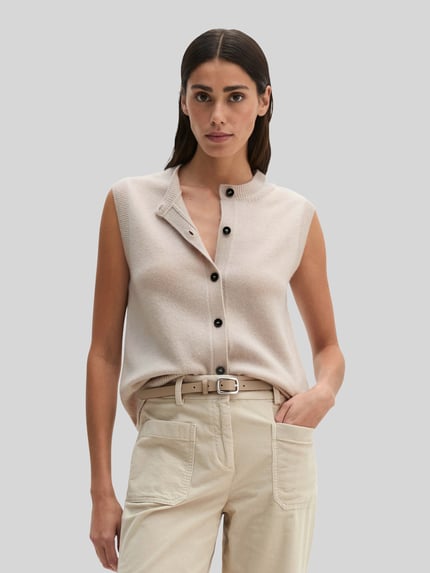 Vrouwenmodel draagt Regular Fit Strickweste aus reiner Schurwolle van Marc O'Polo, beige tinten, zachte textuur, nahaufnahme bovenlichaam.