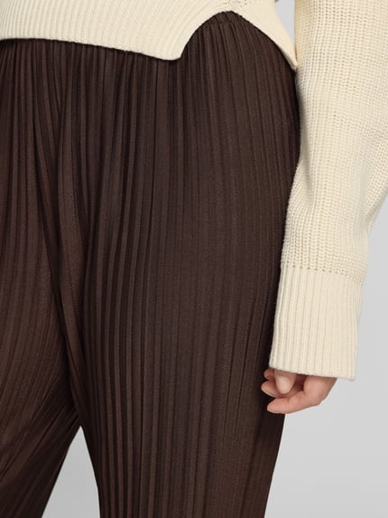 Frauenmodel trägt Plisseehose mit elastischem Bund Modell 'Or44nella' von ZABAIONE im Material-Mix mit Stretch, Nahaufnahme Oberkörper.