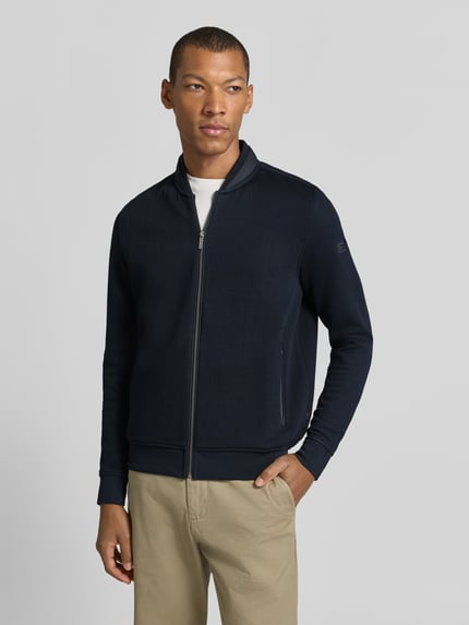 Männermodel trägt Sweatjacke mit Reißverschluss von bugatti, bawełniany miks, krój regular fit, wzór strukturalny, granat, zamek, kieszenie na zamek, długość tyłu w rozmiarze M: 58 cm, długość rękawa w rozmiarze M: 67 cm, Ganzkörperansicht von vorne