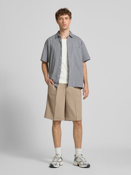 Mannelijk model draagt Loose Fit Chinoshorts met viscose van Only & Sons in beige, zachte structuur, heren, full-body vooraanzicht.