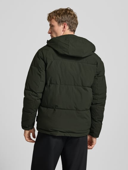 Männermodel trägt Steppjacke mit Kapuze Modell 'GALAXY' von JACK & JONES in Dunkelgrün, strukturierte Oberfläche, Ganzkörperansicht Rückansicht. Regular Fit, Reißverschluss, Eingrifftaschen, Rückenlänge 70 cm, Schulterbreite 49 cm, Brustweite 58 cm, Ärmellänge 69 cm.