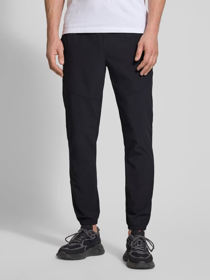 Männermodel trägt schwarze Regular Fit Sweatpants mit Logo-Print Modell 'Vibe' von Under Armour, Elastischer-Material-Mix, Ganzkörperansicht von vorne.