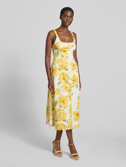 Frauenmodel trägt Midikleid im Allover-Look Modell 'ISLAND' von MANGO aus Baumwoll-Elasthan-Mix mit Karree-Ausschnitt, A-Linie, gelb-weiße florale Muster, strukturierte Oberfläche, Ganzkörperansicht von vorne. Rückenlänge bei Größe S: 100 cm, Brustweite: 39 cm.