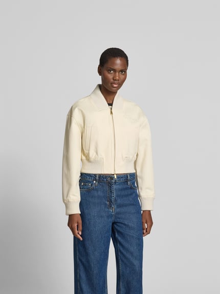 Frauenmodel trägt Regular Fit Bomberjacke mit Stehkragen von Self-Portrait in Creme, Baumwolle, elastische Abschlüsse, Ganzkörperansicht von vorne
