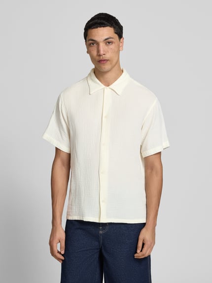 Männermodel trägt Regular Fit Freizeithemd mit Kentkragen von Jack & JonesR, reine Baumwolle, cremefarben, strukturierte Textur, Nahaufnahme Oberkörper.
