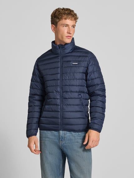 Männermodel trägt dunkelblaue Jacke mit Label-Patch Modell 'ELVIS' von JACK & JONES, Stehkragen, gerader Schnitt, Ganzkörperansicht von vorne