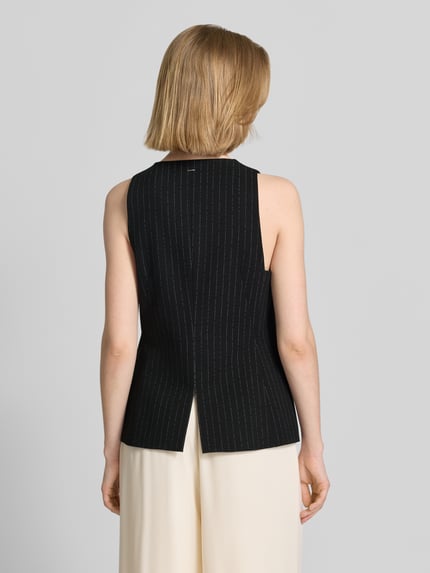 Frauenmodel trägt Slim Fit Weste aus reiner Viskose Modell 'JULERAN' von BOSS mit Nadelstreifen-Muster und Gehschlitz, Ganzkörperansicht Rückansicht.
