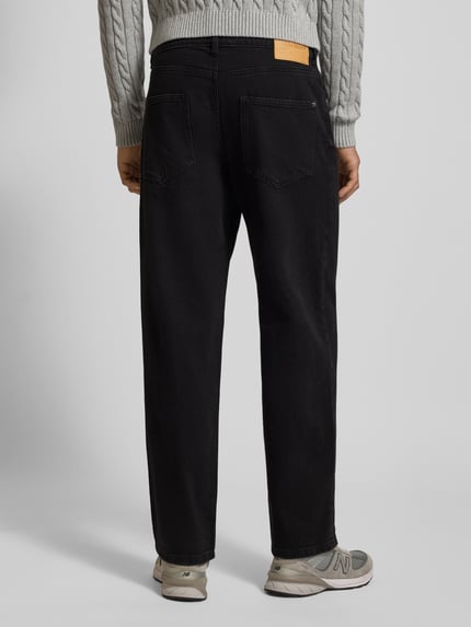 Männermodel trägt Baggy Fit Jeans mit Knopfverschluss von REVIEW in Schwarz, 5-Pocket-Design, strukturierter Stoff, Ganzkörperansicht Rückansicht.