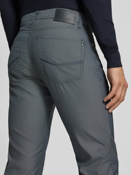 Männermodel trägt Regular Fit Hose mit Label-Detail Modell 'Lyon' von Pierre Cardin, blau-grau, fein strukturiert, Nahaufnahme Rückansicht. Herren Hose aus Baumwoll-Mix mit Stretch-Anteil, Bundweite 43 cm, Innenbeinlänge 79 cm.