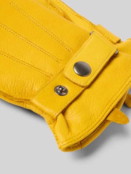 Produktfoto, Handschuhe aus Rindsnappa mit Ziernähten von Akaroa in gelber Lederoptik mit Struktur und sichtbaren Nähten auf grauem Hintergrund