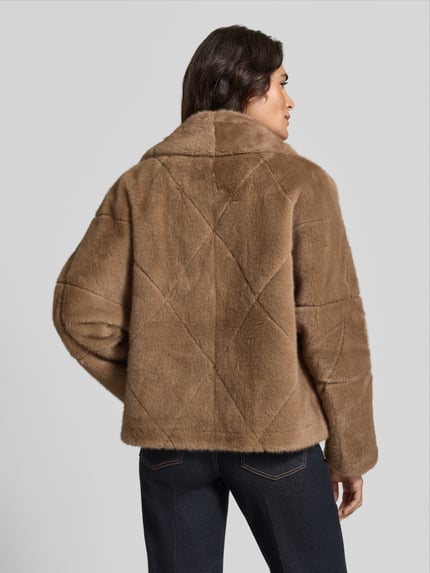 Frauenmodel trägt Jacke mit Umlegekragen Modell 'PINIE' von ba&sh in Hellbraun mit Rautenstruktur, gerade geschnitten, Ganzkörperansicht Rückansicht.