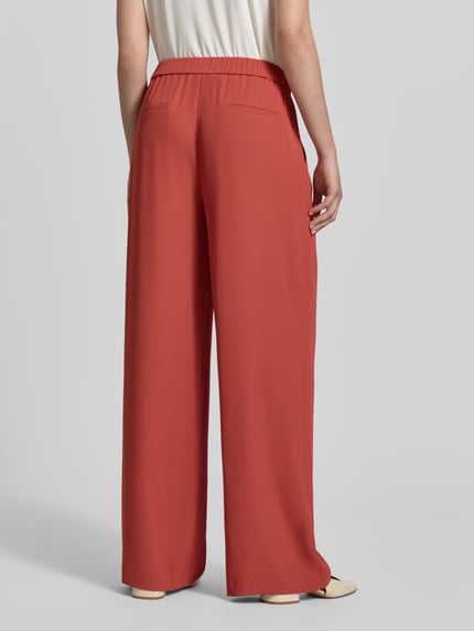 Frauenmodel trägt Wide Fit Hose mit Gesäßtaschen von Jake*s Collection in Rot aus Elastischer-Material-Mix, Teilelastischer Bund, Ganzkörperansicht Rückansicht.