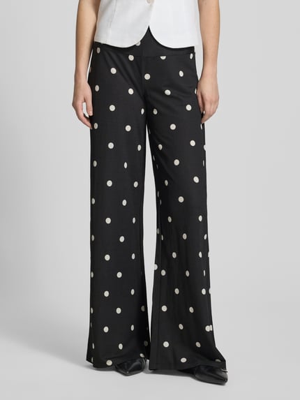 Vrouwenmodel draagt Wide Leg Pants uit viscosemix met zijritssluiting, polkadots, los model van Gina Tricot, voorkant, close-up onderlichaam.