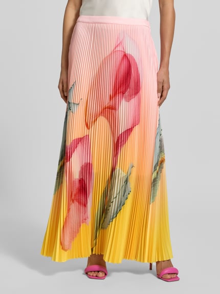 Vrouwenmodel draagt maxirok in plissée-look van Marc Cain, elastische materiaalmix, straight fit, bloemen all-over print, bandwijdte maat 36: 37 cm, totale lengte maat 36: 100 cm, frontale close-up bovenbenen.
