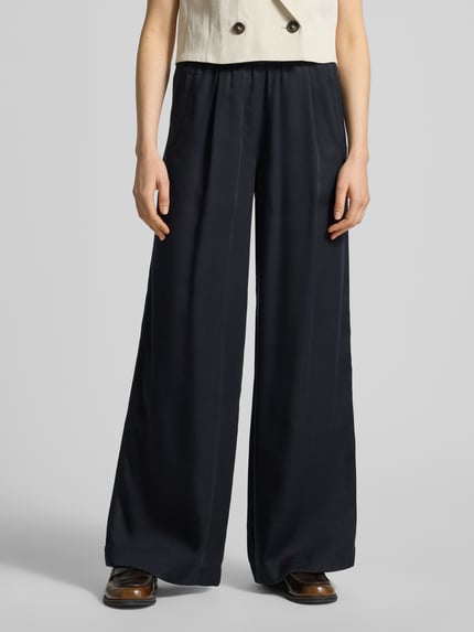 Frauenmodel trägt Wide Leg Stoffhose mit elastischem Bund von Lanius aus reinem Lyocell in Dunkelblau, mit Eingrifftaschen, Ganzkörperansicht von vorne.