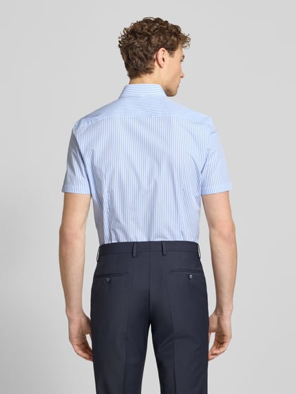 Männermodel trägt Slim Fit Business-Hemd aus Baumwolle mit Kentkragen von Jake*s, feine blaue Streifen, kurze Ärmel, Ganzkörperansicht Rückansicht