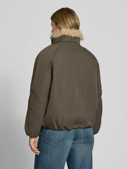 Frauenmodel trägt Bomberjacke mit Webpelzkragen Modell 'ONLAUDREY' von ONLY in einfarbigem Olivgrün, elastische Abschlüsse, Ganzkörperansicht Rückansicht, Webware