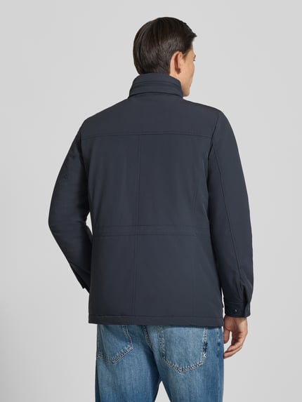 Männermodel trägt Funktionsjacke mit vielen Taschen von Geox in Dunkelblau, Regular Fit, glatte Textur, Ganzkörperansicht Rückansicht.