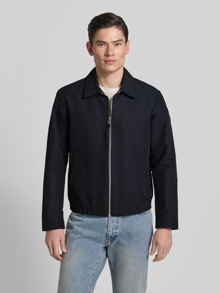 Männermodel trägt Regular Fit Blouson mit Label Patch - Marc O'Polo × DFB Travel Collection, Optik: Unifarben, Ganzkörperansicht von vorne.