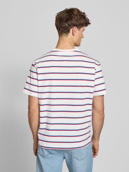Mannelijk model draagt Regular Fit T-shirt uit puur katoen van Tommy Jeans met all-over motief, gestreept patroon, logostitching, jerseyverwerking, ronde hals en korte mouw, heren t-shirtlook, geheelopname rugaanzicht.