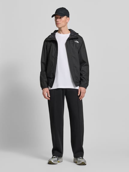 Männermodel trägt Regular Fit Jacke mit Logo-Print Modell 'Quest' von The North Face in Schwarz, glatte Textur, Ganzkörperansicht von vorne. Rückenlänge, Schulterbreite, Brustweite und Ärmellänge gemäß Größe M.