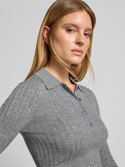 Frauenmodel trägt Henley-Shirt aus Wolle - curated by Viky Rader von Style Icon Collection in Grau, Ripp- und Strick-Optik, Skinny Fit, Polokragen, reine Baumwolle, Nahaufnahme Oberkörper.
