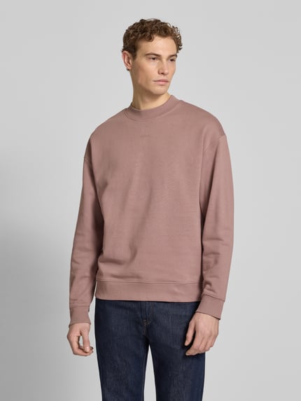 Männermodel trägt Regular Fit Sweatshirt aus reiner Baumwolle Modell 'DAPOCREW' von HUGO, unifarben, Rundhals, Label Print, Ganzkörperansicht von vorne