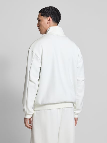 Männermodel trägt Regular Fit Sweatjacke aus reiner Baumwolle von adidas Sportswear in Unifarben mit Stehkragen, Ganzkörperansicht Rückansicht.