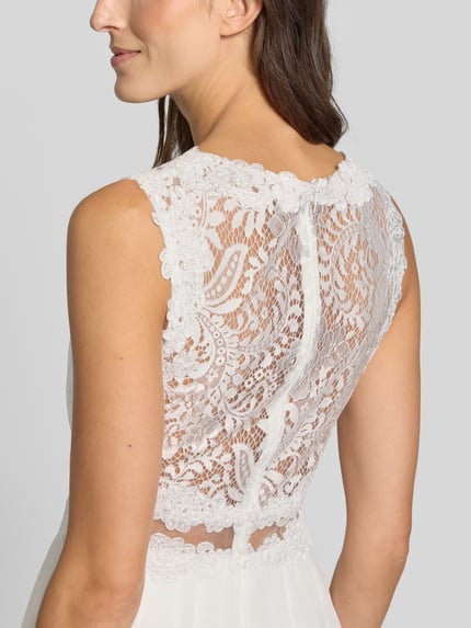 Frauenmodel trägt Cocktailkleid mit Spitze und Rundhalsausschnitt von Mascara, Chiffon, A-Linie, Midikleid, Detailaufnahme Rückenpartie.