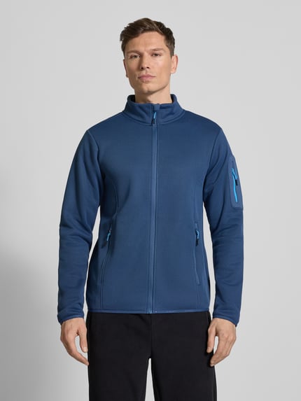 Męski model nosi Regular Fit Kurtka ze stójką Model 'BREDSTEDT' od Icepeak, kolor niebieski, krój regular fit, wpuszczane kieszenie zapinane na zamek błyskawiczny, zamek błyskawiczny, elastyczne wykończenia, długość tyłu w rozmiarze M: 69 cm, szerokość ramion w rozmiarze M: 43 cm, szerokość w rozmiarze M: 54 cm, długość rękawów w rozmiarze M: 67 cm, tekstura gładka, jednolity kolor, widok na cały przód.