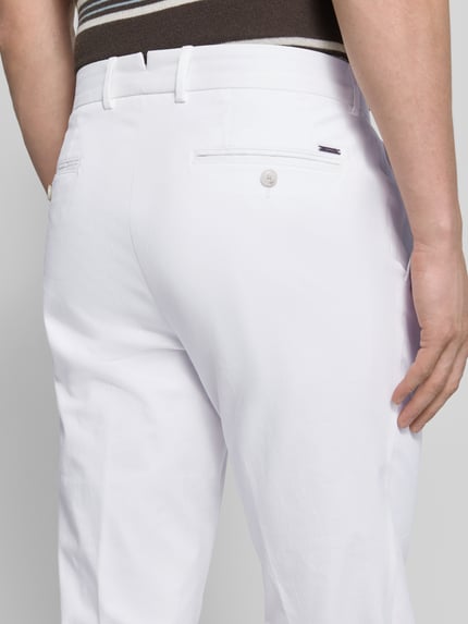 Mannenmodel draagt Slim Fit Hose aus Baumwoll-Mix Modell 'H-GENIUS' van BOSS, witte twill broek met steekzakken en achterzakken, detailopname rug.