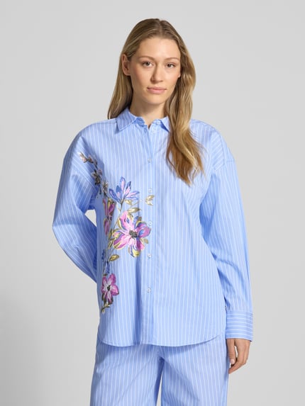 Frauenmodel trägt Regular Fit Hemdbluse mit Kentkragen von Fynch-Hatton, blau mit weißen Streifen und floralen Details, Knopfleiste, überschnittene Schultern, Sportmanschetten, Rückenlänge bei Größe 36: 71 cm, Ärmellänge bei Größe 36: 52 cm, Ganzkörperansicht von vorne.