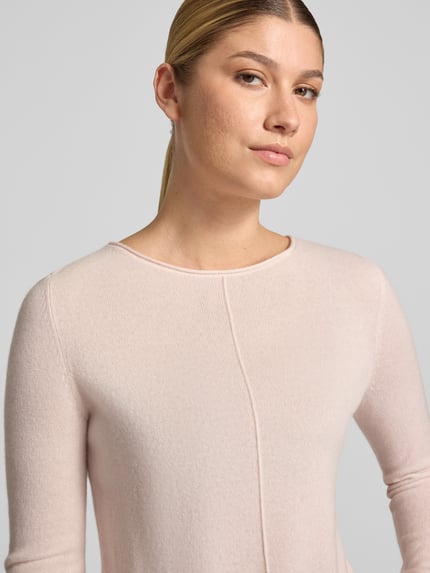 Frauenmodel trägt Regular Fit Strickpullover aus reinem Kaschmir von Christian Berg Woman in zartem Rosa mit Ziernaht, Nahaufnahme Oberkörper.