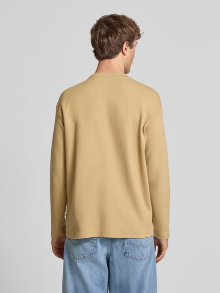 Männermodel trägt Longsleeve aus Baumwolle Modell 'FILLIP' von Blend in Beige mit Gerader-Schnitt, Rückenlänge 70 cm, Ganzkörperansicht Rückansicht.