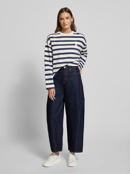 Vrouwenmodel draagt Barrel Jeans uit katoenmix model 'KAITLIN' van Vero Moda, donkere melange denim, 5-pocket, knoopsluiting, voorkant volledig lichaam.