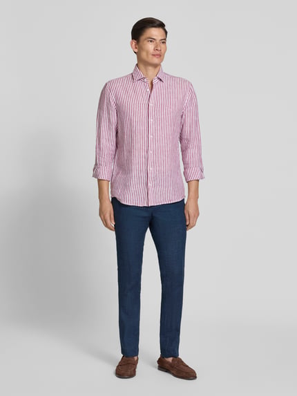 Männermodel trägt Leinenhose mit französischen Eingrifftaschen Modell 'Tomte' von Carl Gross in Dunkelblau, Straight Fit, Ganzkörperansicht von vorne.