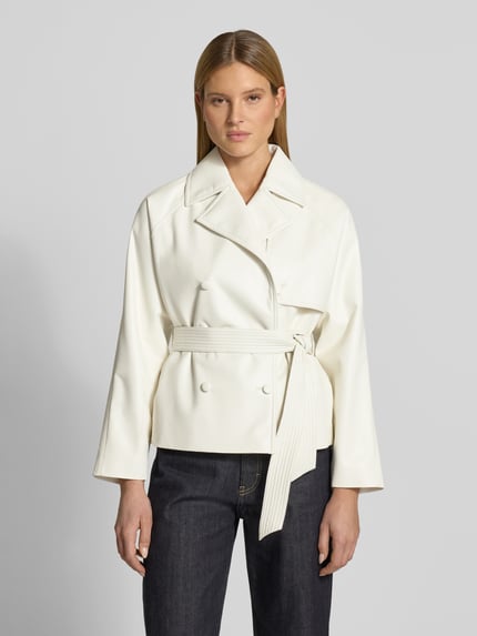 Frauenmodel trägt Regular Fit Kunstlederjacke mit Bindegürtel Modell 'AISANDI' von HUGO in Unifarbe, Glattleder, Reverskragen, Doppelknopfleiste, Seitentaschen, Ganzkörperansicht von vorne.