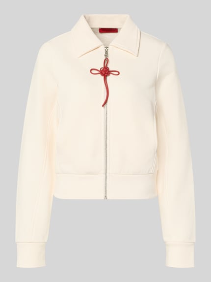 Produktfoto, Slim Fit Sweatjacke aus reiner Baumwolle Modell 'EROICO' von MAX&Co., cremefarben, rote Schleife, Hemdkragen, Reißverschluss, unifarbene Sweat-Optik, metallische Akzente, gerippte Abschlüsse, seitliche Eingrifftaschen