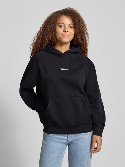 Frauenmodel trägt Hoodie mit Label-Stitching von Pegador aus Baumwoll-Mix, lockerer Schnitt, Kapuze, Känguru-Tasche, gerippte Abschlüsse, Ganzkörperansicht von vorne