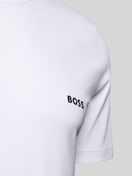 Männermodel trägt Regular Fit T-Shirt aus reiner Baumwolle im 3er-Pack Modell 'CLASSIC' von BOSS, Optik: Unifarben, Label-Schriftzug, Nahaufnahme Oberkörper.