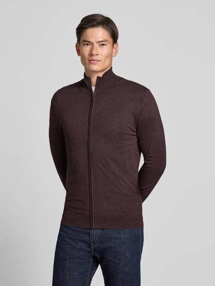 Männermodel trägt Slim Fit Strickjacke aus Viskose-Mix mit Stehkragen von MCNEAL, dunkelbraun, Reißverschluss, Ganzkörperansicht von vorne.